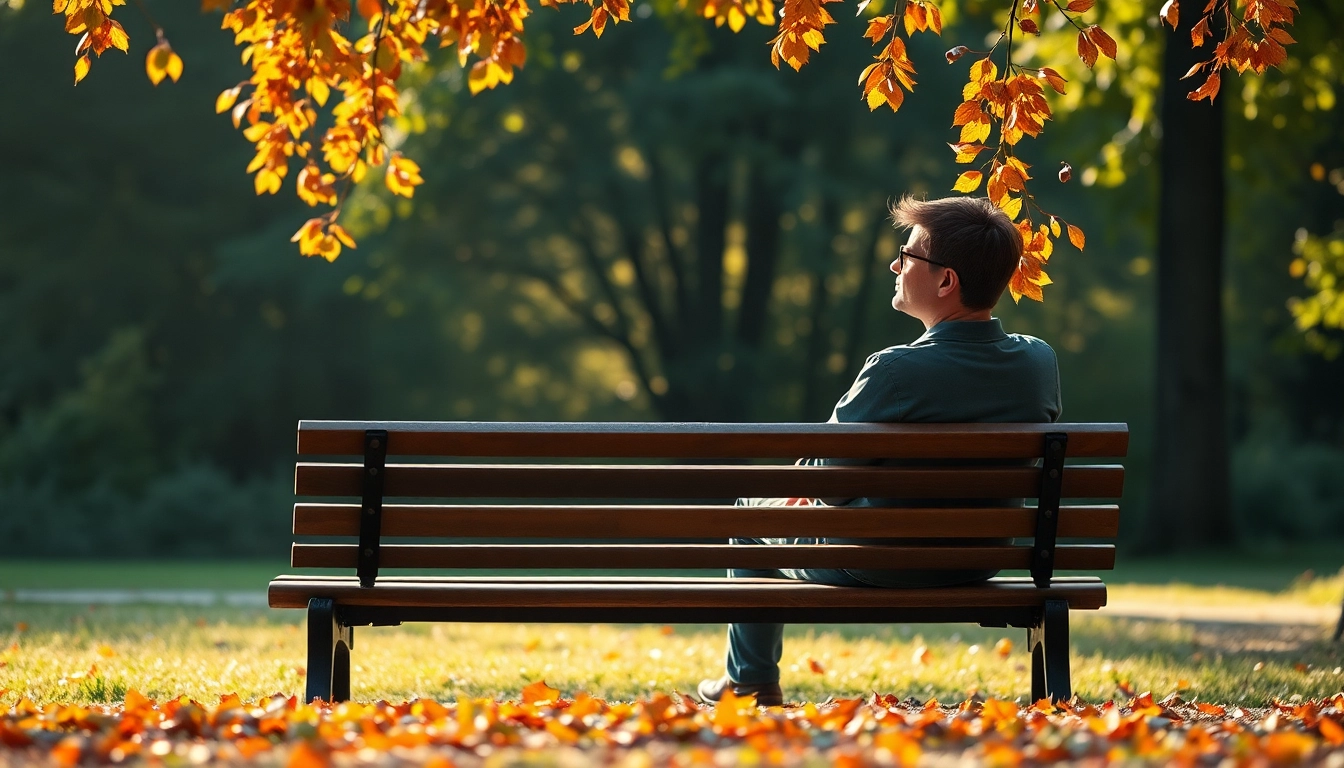 Person reflecting on dealing with grief while sitting on a park bench surrounded by autumn leaves.